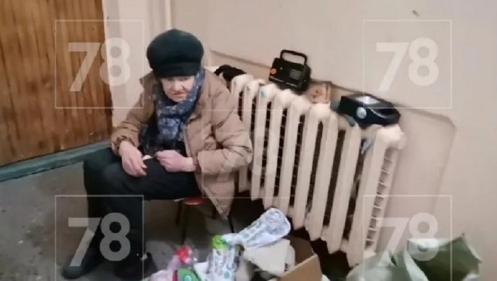 Пенсионерка ждет помощи в подъезде после пожара в квартире - фото