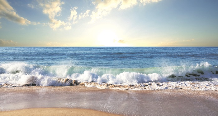 Солнечный пляж и голубое море с волнами